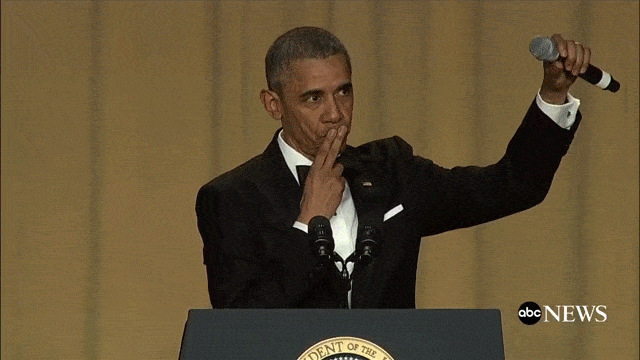 President Obama drops a microphone from his left hand as he leaves the podium