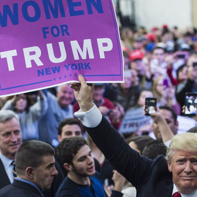 Donald Trump holds a sign that reads "Women for Trump New York" in a crowd