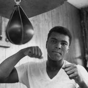 a young Muhammad Ali punches a punching bag