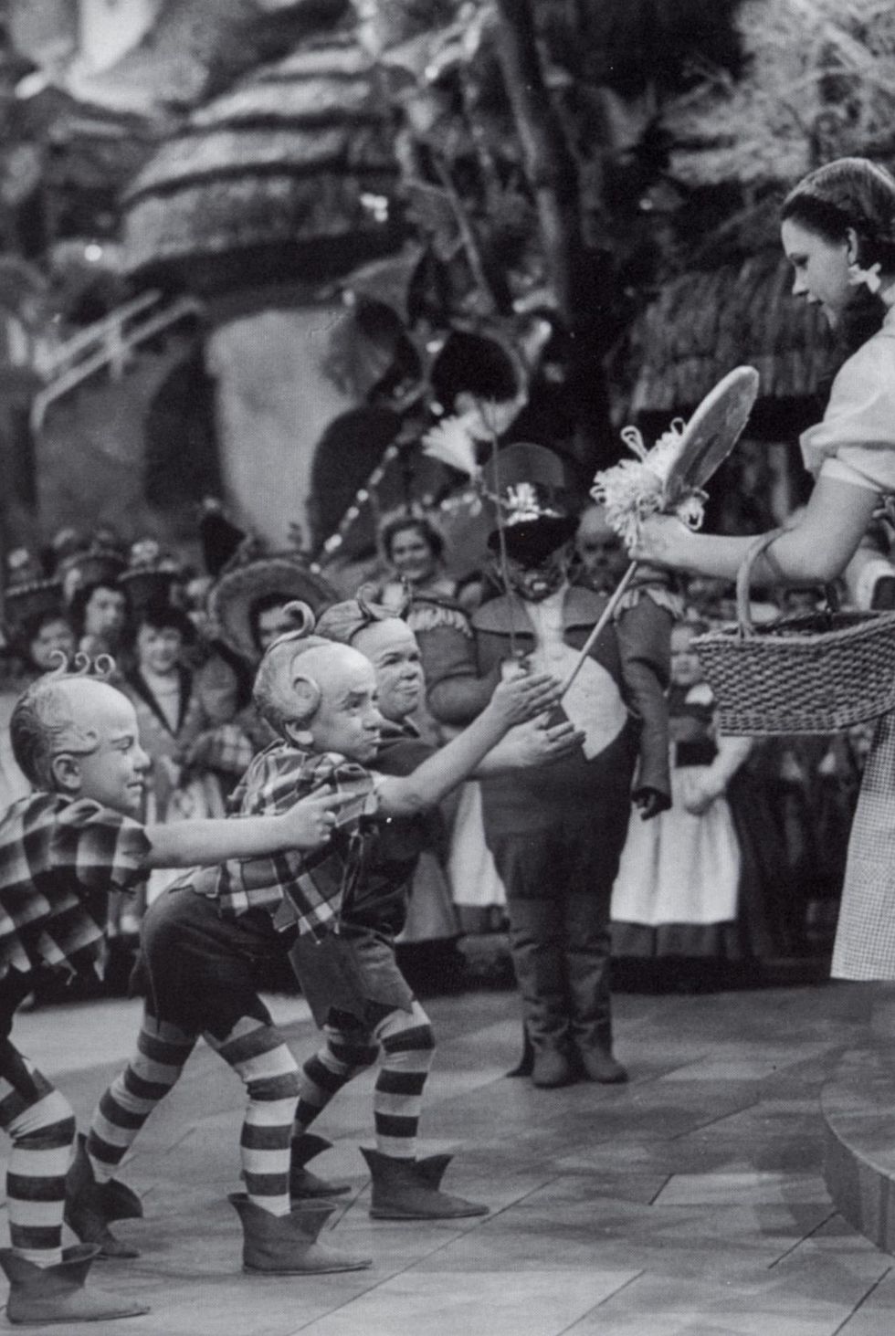 Jerry Maren, playing a Lollipop Guild Member, presents Judy Garland with a lollipop in the film 'The Wizard of Oz.'