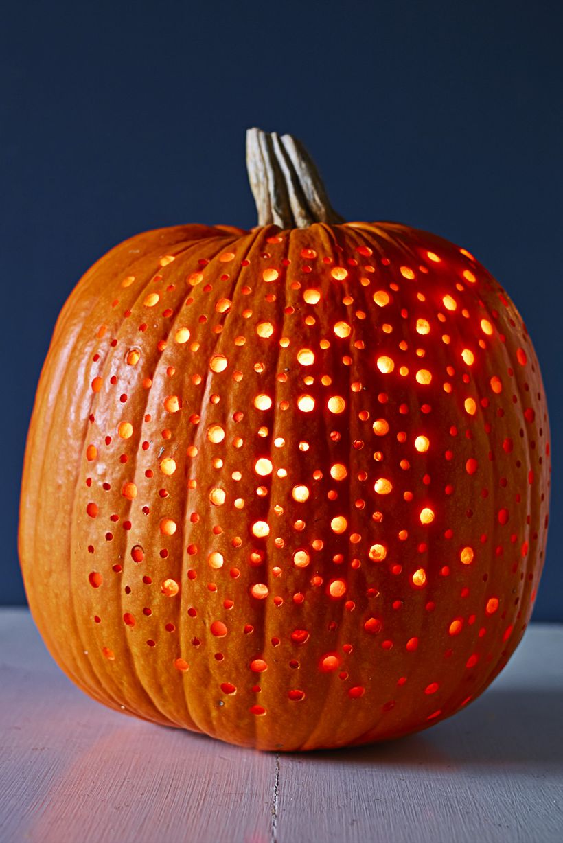 pumpkin carving ideas, pumpkin with small cutout spots and a glow inside