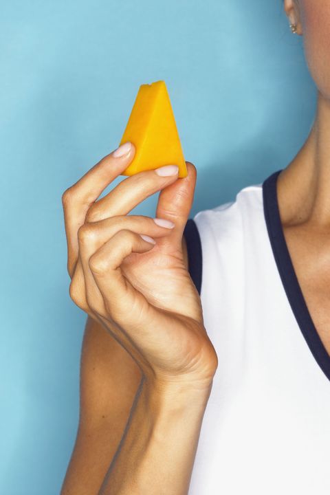 woman holding cheese wedge