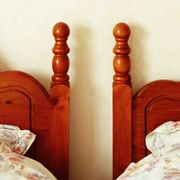 couple sleep in separate double twin beds