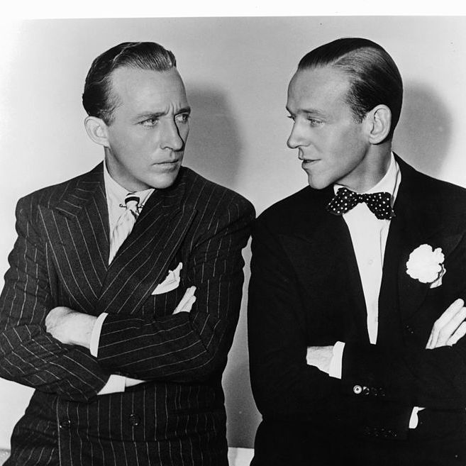 bing crosby and fred astaire with their arms folded staring at one an other in a scene from the film 'holiday inn', 1942