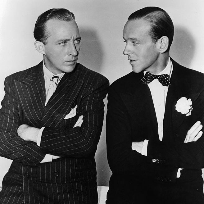 bing crosby and fred astaire with their arms folded staring at one an other in a scene from the film 'holiday inn', 1942