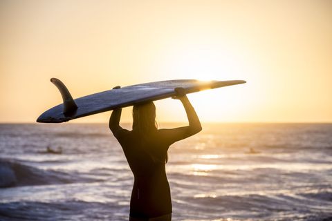 woman surfing sunset