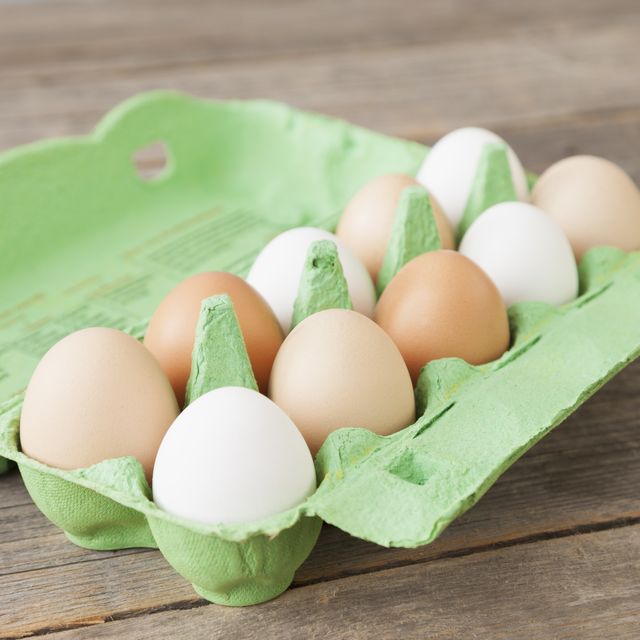 eggs in a green carton on a wooden table