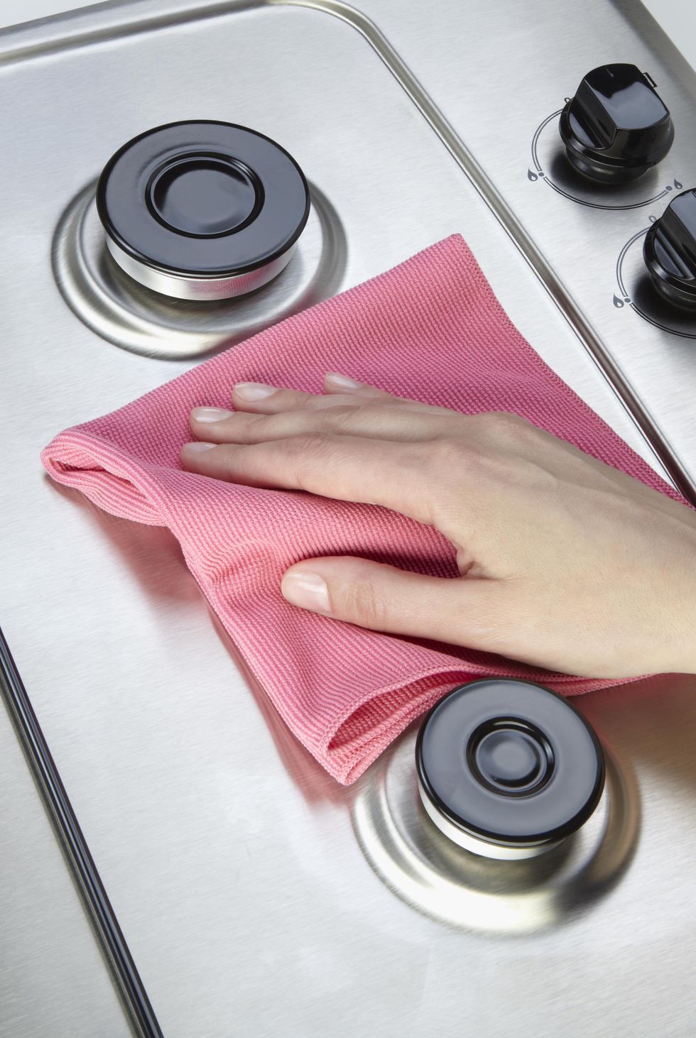 pink cloth cleaning stainless steel stovetop
