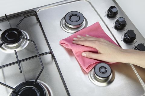 pink cloth cleaning stainless steel stovetop