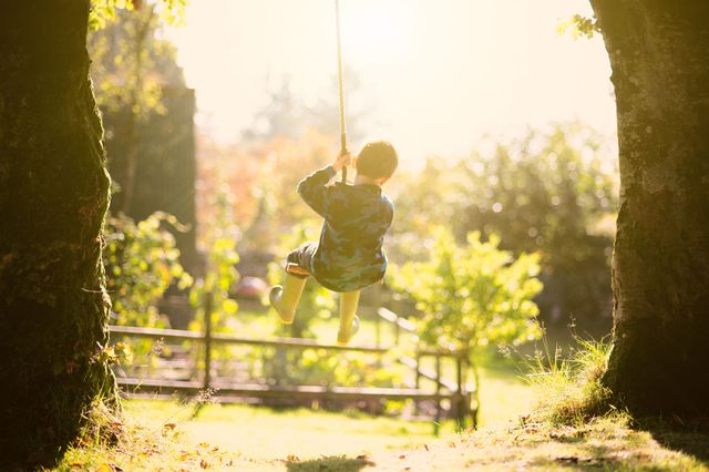 kid playing on swing in backyard