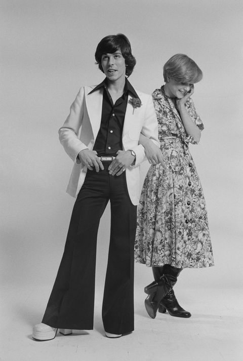 English singer David Van Day, of pop group Guys 'n' Dolls, and a young woman, modelling fashionable outfits, 24th March 1975. (Photo by Michael Putland/Getty Images)