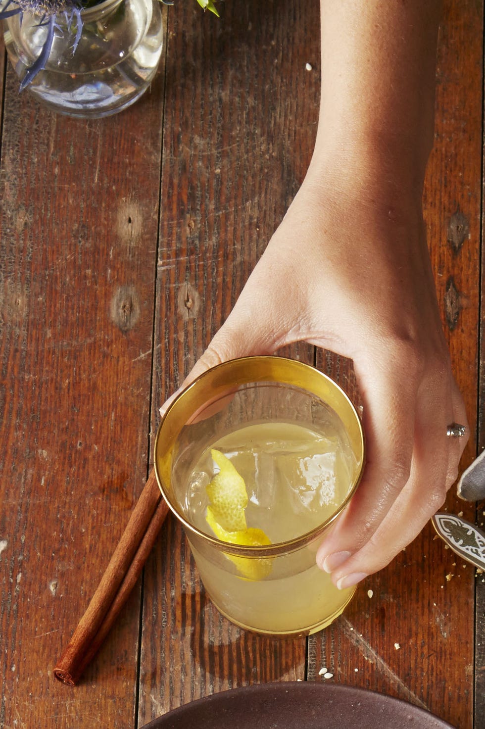 a glass of citrus whiskey punch on a wooden table
