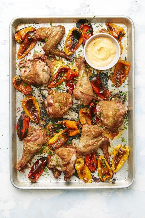 spanish chicken and peppers  on a sheet pan with a dipping sauce on the side