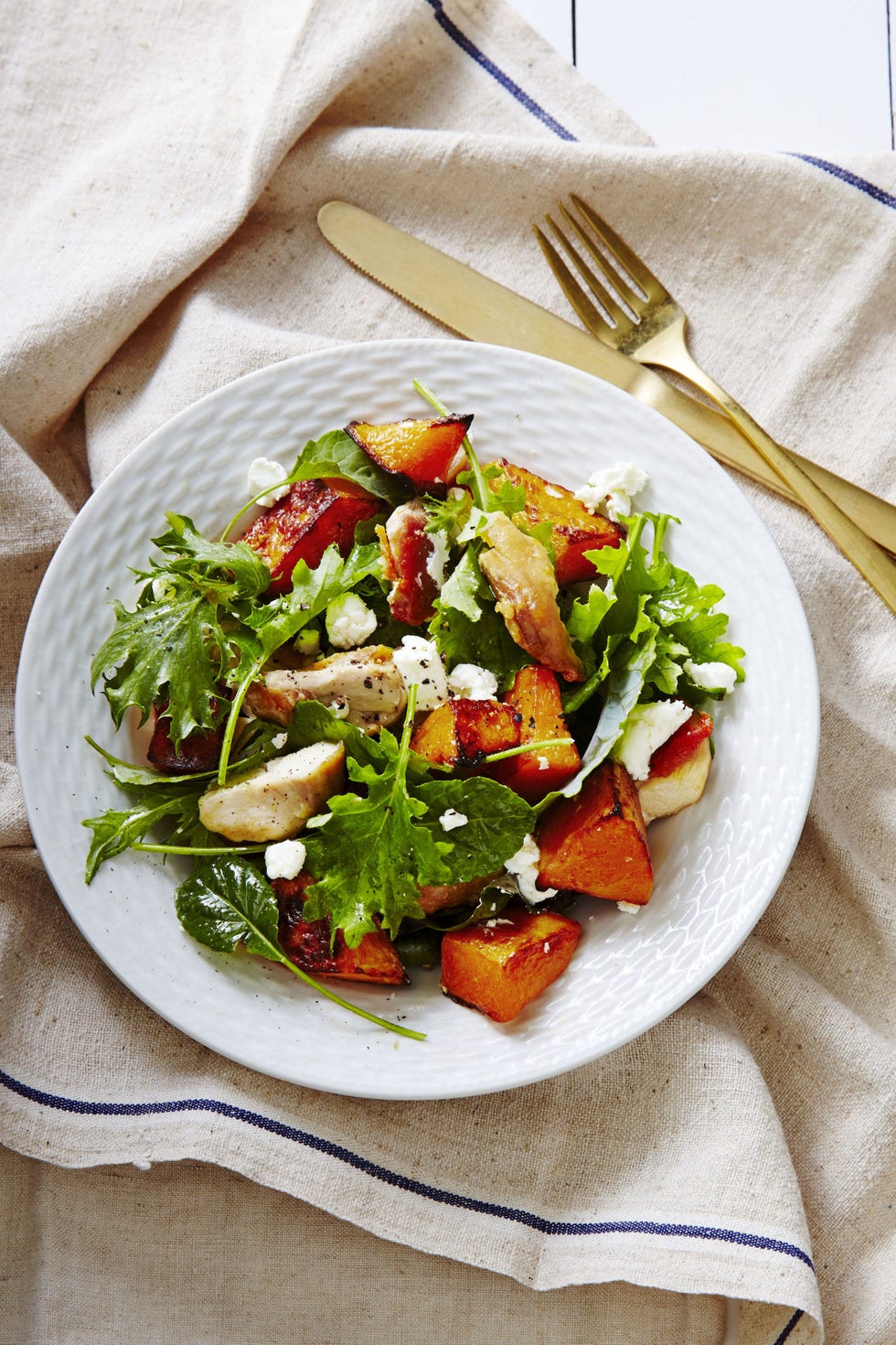 green salad with chicken, butternut squahs and goat cheese