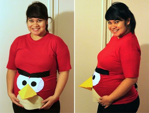 a woman dresses her belly as an angry bird as part of a pregnant halloween costume
