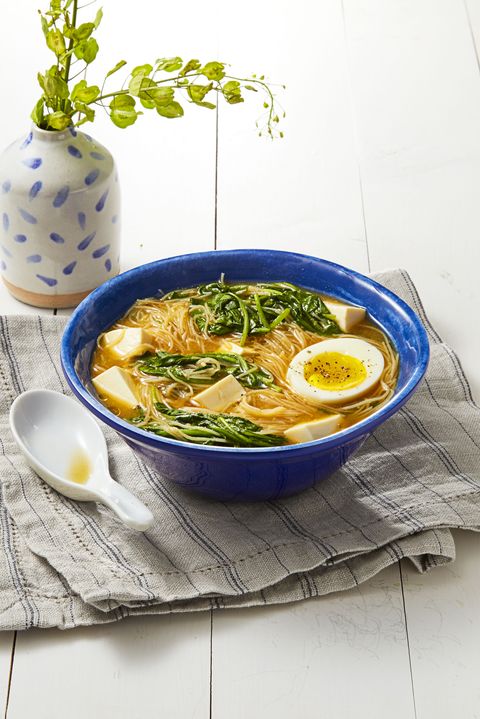 miso spinach noodle soup with a soft boiled egg in a blue bowl