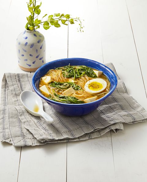 miso spinach noodle soup with a soft boiled egg in a blue bowl