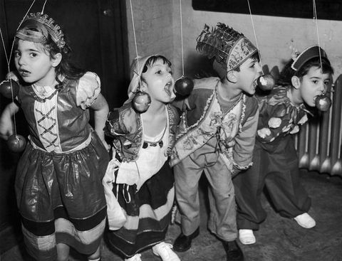 circa 1940: From left to right, Elizabeth Bianco, Barbara Lee, Anthony Dimino and Theresa Imbronone join in the fun at a Halloween party in New York City. The party was organised for members of Tots' Town, a day care facility at the Children's Aid Society's James Center. (Photo by Keystone/Getty Images)
