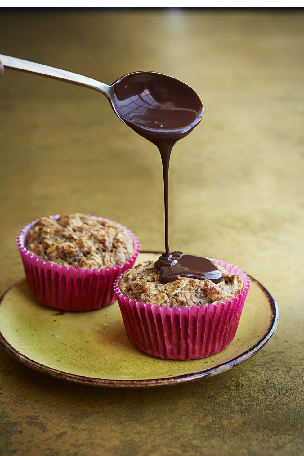 spiced banana chocolate muffins on a yellow plate