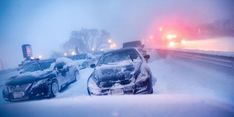 cars stuck on highway in winter snowstorm.