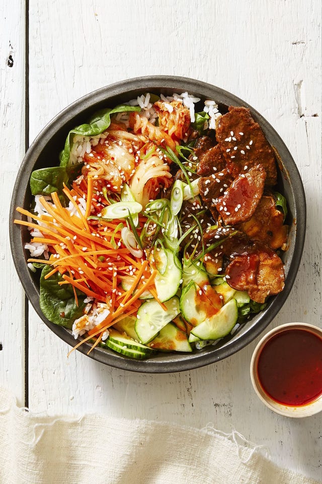 beef, white rice, cucumber, lettuce, sesame seeds, carrots over white rice