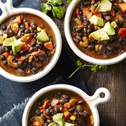 three bowls of hearty fall soup that has avocado, beans, and carrots