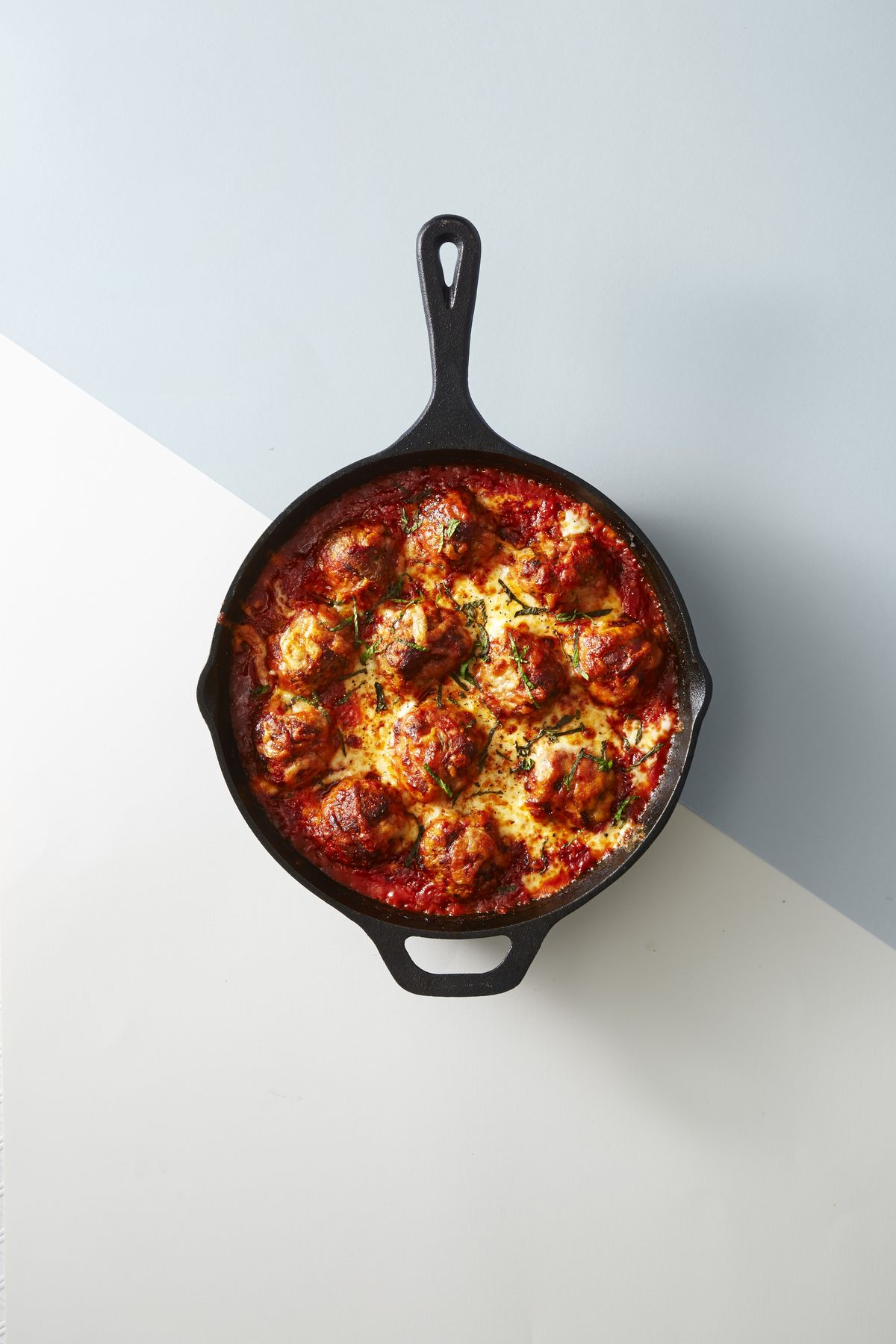 baked meatballs in a forged iron pan Doubly Cheesy Meatball Bake Doubly Cheesy Meatball Bake 1486497203 mike garten meatball bake 0317