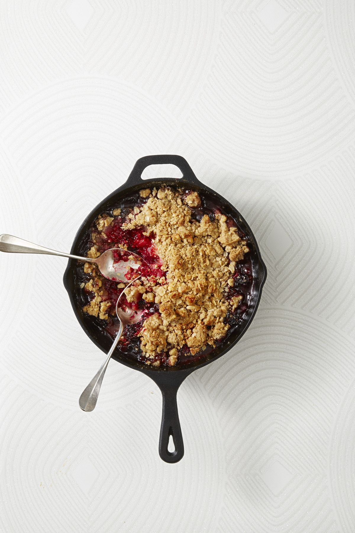 spiced pear and berry crumble in a cast iron pan