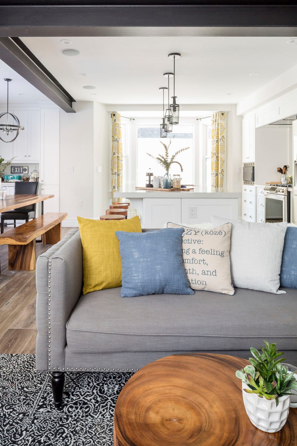 living room ideas open floor plan living space with a grey couch in front and kitchen in the back