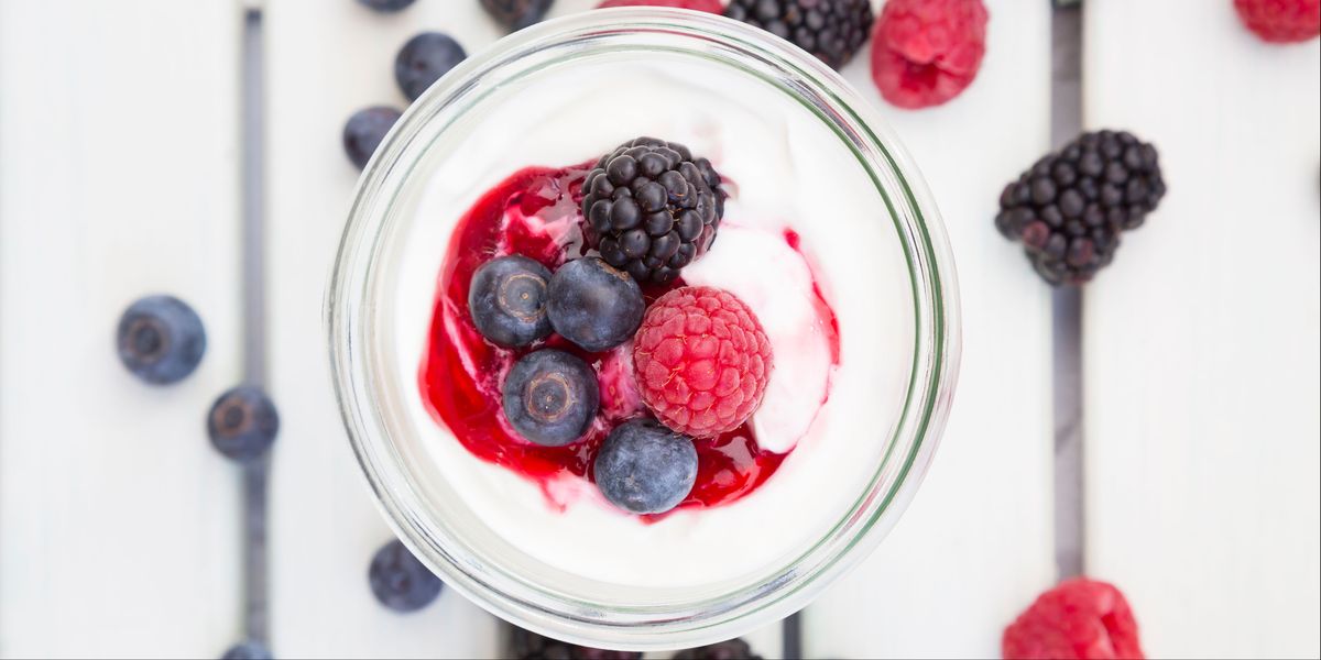 greek yogurt in a glass jar with mixed berries on top