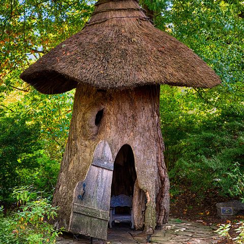 outside, a whimsical children's garden has a giant bird's nest, toadstools, and thatched roof cottages designed for woodland fairies