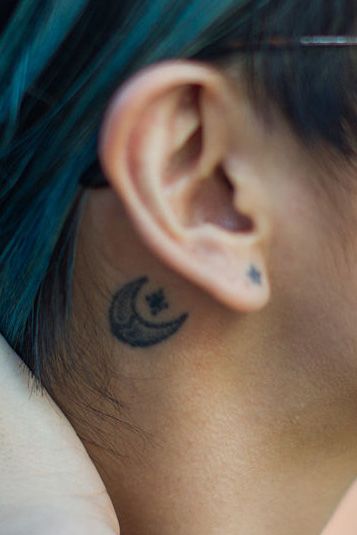 Infinity star and moon tattoo located behind the ear.