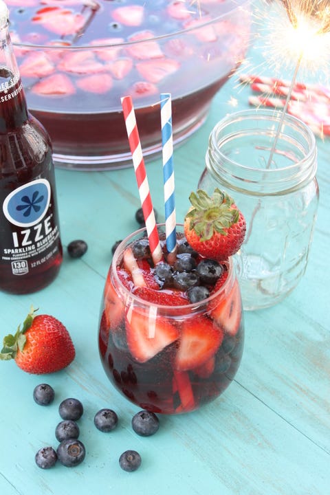 blueberry punch cocktail with fresh strawberries, blueberries and two straws