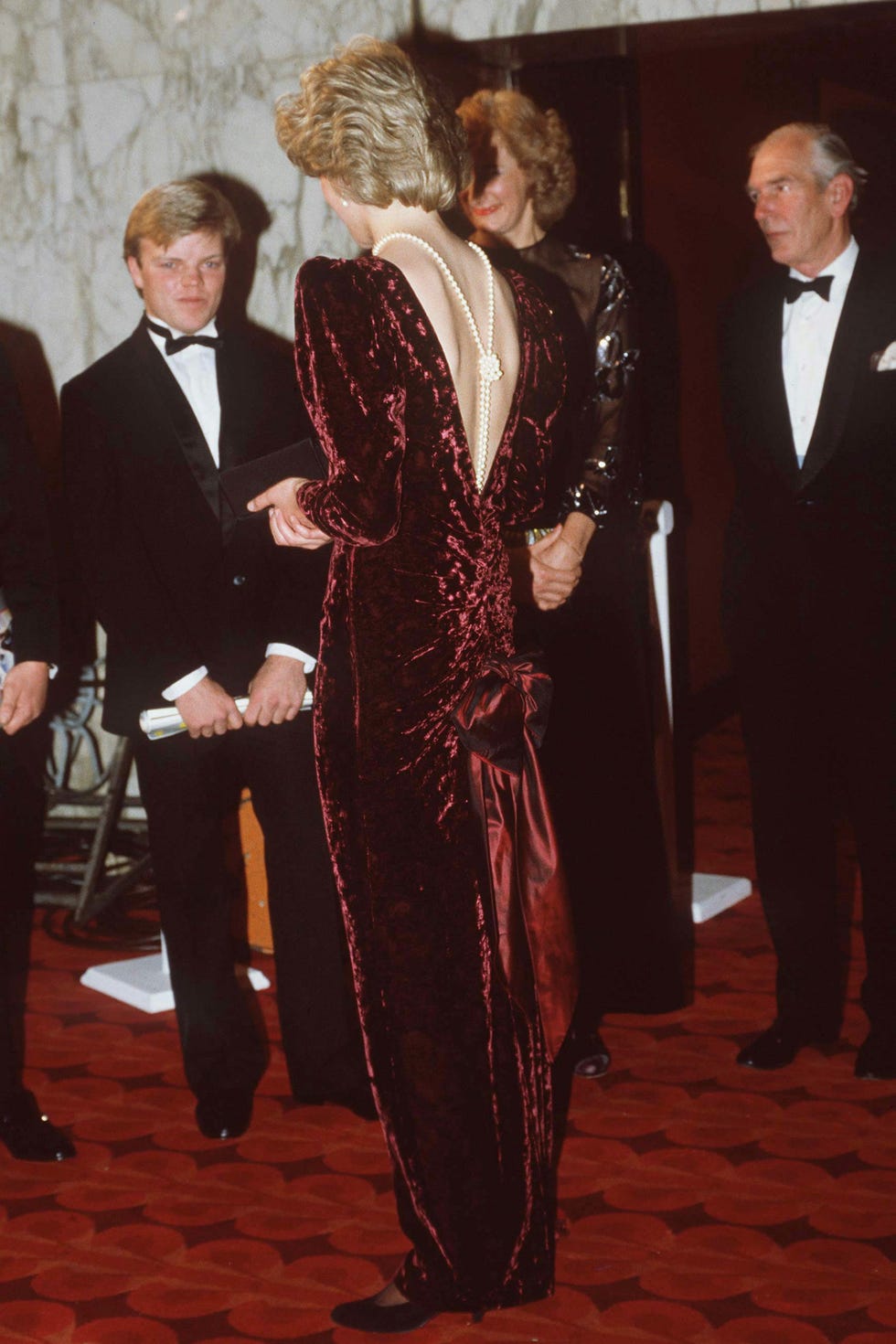 london, united kingdom   december 03  the princess of wales attends the premiere of 'back to the future' at the empire cinema, leicester square, london wearing a burgundy velvet evening dress designed by fashion designer catherine walker and pearls down her back  photo by tim grahamgetty images