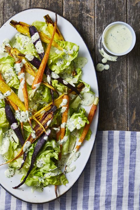 green goddess carrot salad with mixed greens and served on a white plate