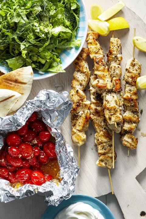 chicken souvlaki on skewers and roasted tomatoes in foil
