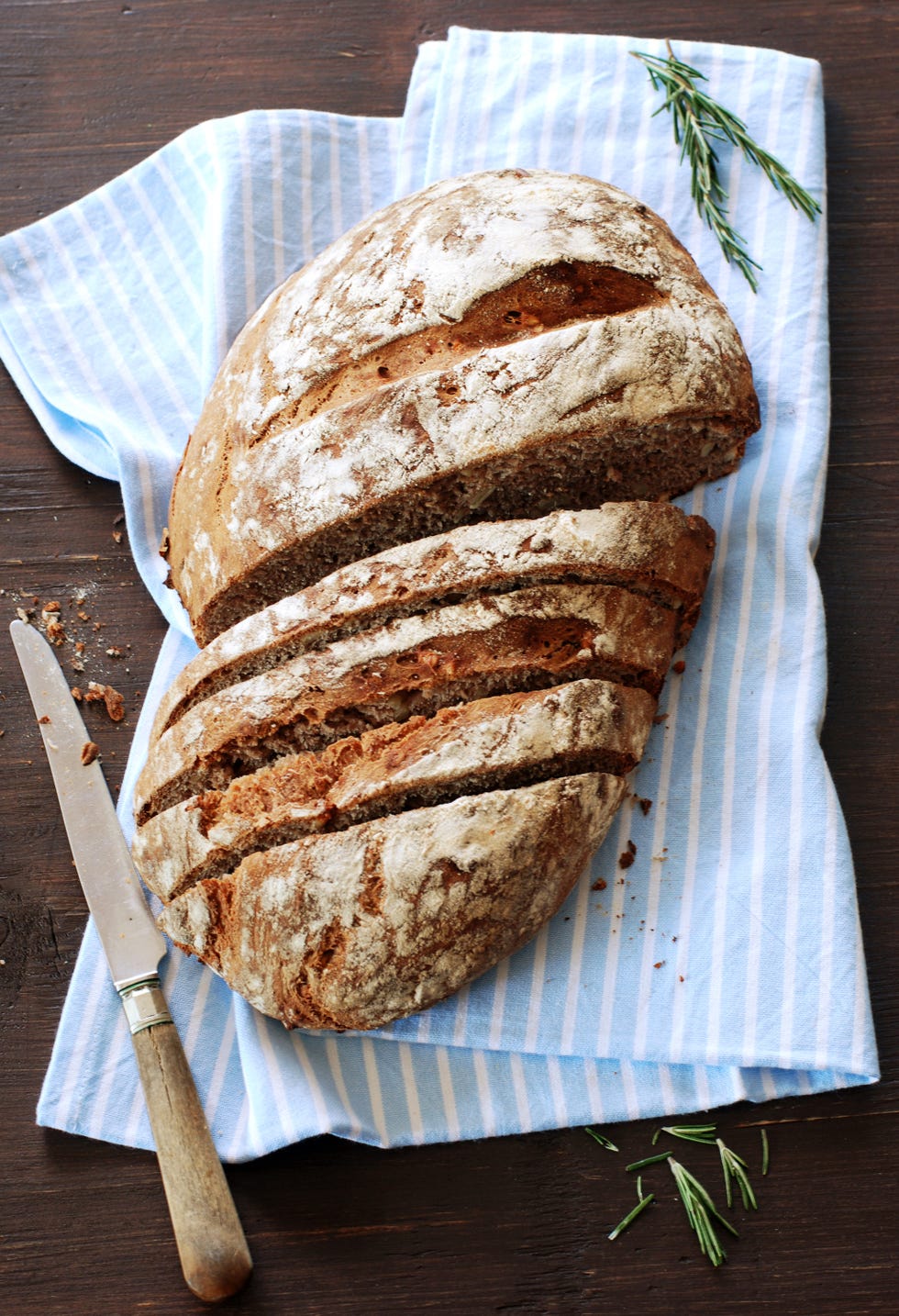 a loaf of partially sliced bread on a kitchen towel