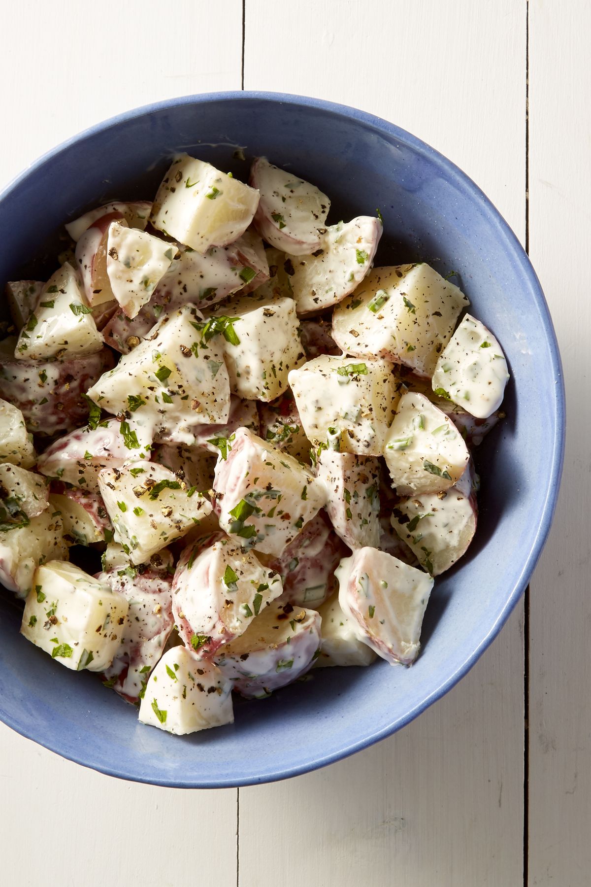 creamy potato salad with fresh herbs on top