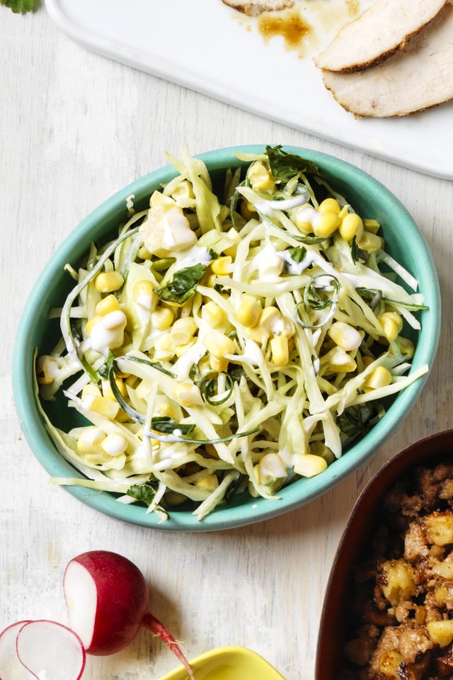 cabbage slaw tossed with corn and a creamy dressing in a blue bowl