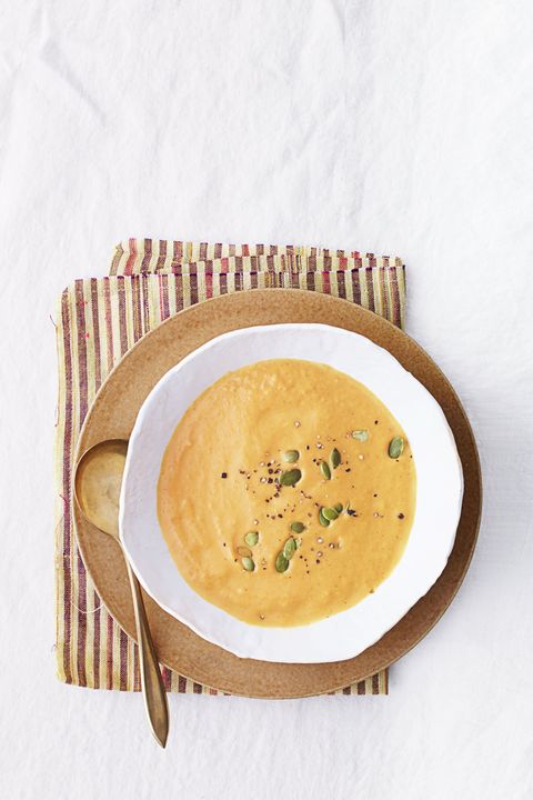 pumpkin soup with pepita seeds in a white bowl