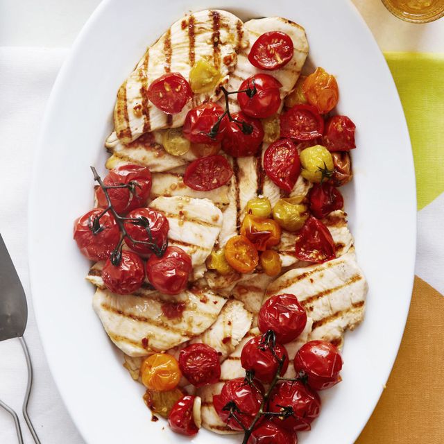 roasted baby vine tomato with grilled chicken on a white plate