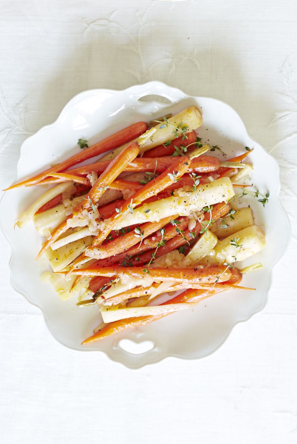 orange braised carrots and parsnips on a white plate
