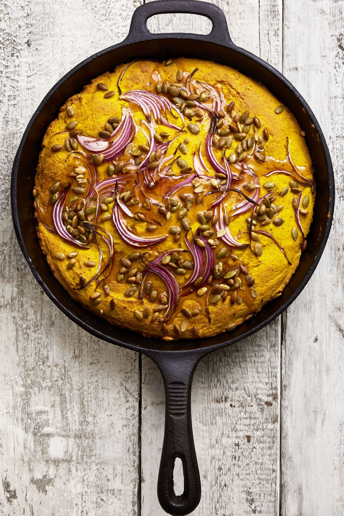 baked cornbread with red onion in a cast iron skillet