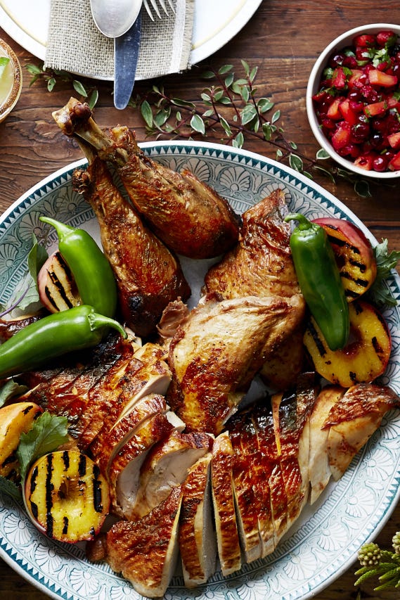 sliced thanksgiving turkey with roasted jalapenos and peaches on the side