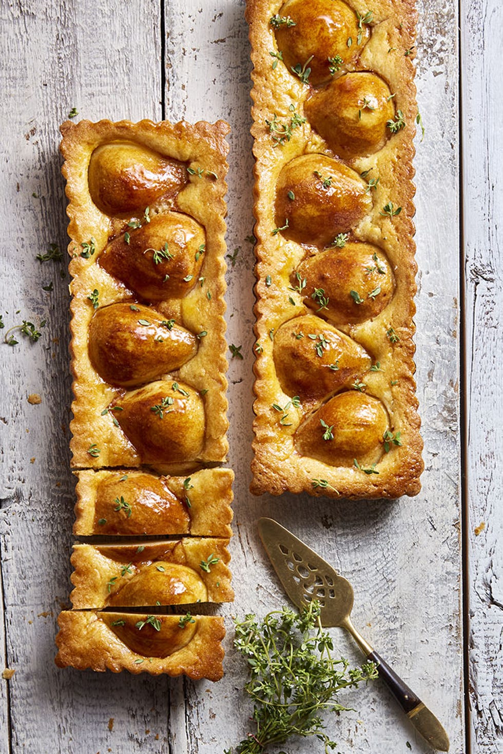lemon and thyme pear tart with apricot glaze on a wooden board