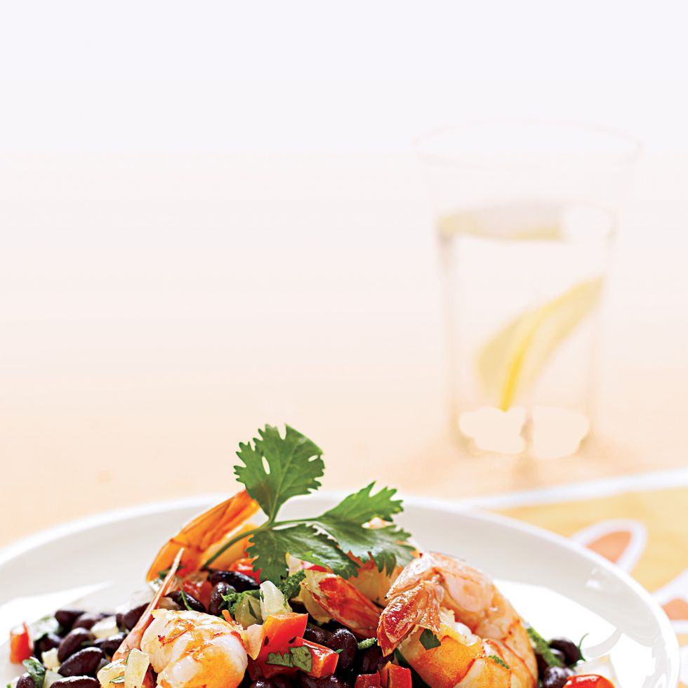 sauteed shrimp on warm black bean salad on a white plate
