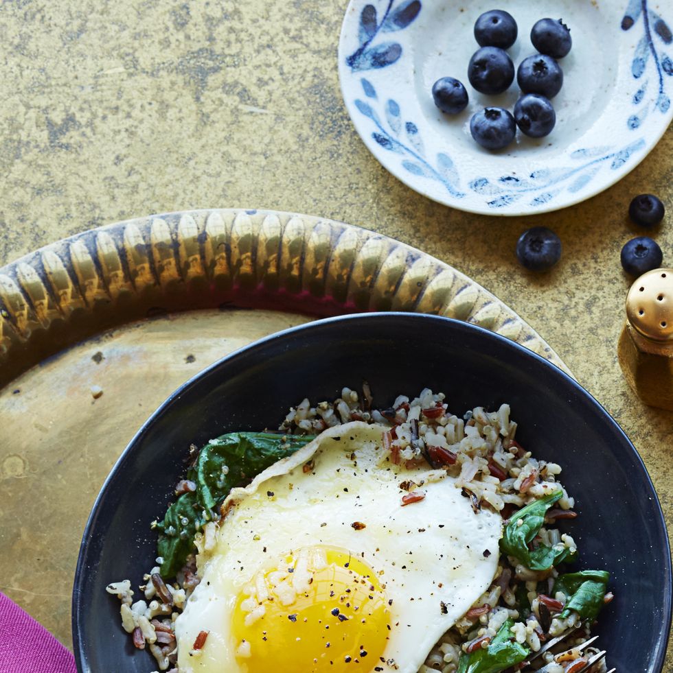 mediterranean diet rice medley with a fried egg on a black plate