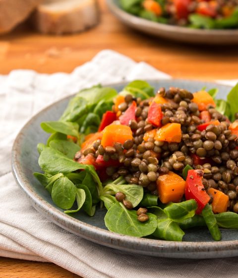 lentil salad on spinach greens on a grey plate