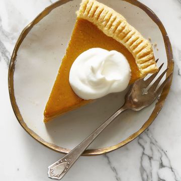 a slice of pumpkin pie with a dollop of whipped cream on top