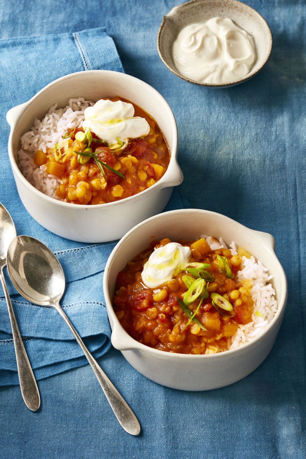 butternut squash stew in a white bowl on blue cloth surface